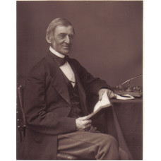 Portrait Photograph of  Emerson, looking right, seated at his desk, with an open book in his hands, by Elliott & Fry.